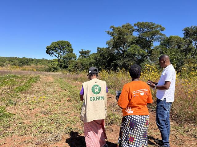 A field monitor and farmer recording observations beside a plot