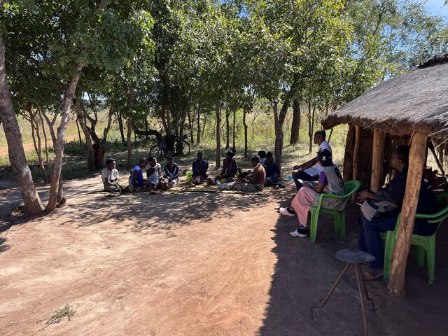 Women farmers meeting in a circle under the trees